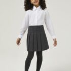 Child wearing long sleeve school blouse as part of a school uniform outfit