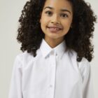 Child wearing long sleeve school blouse as part of a school uniform outfit